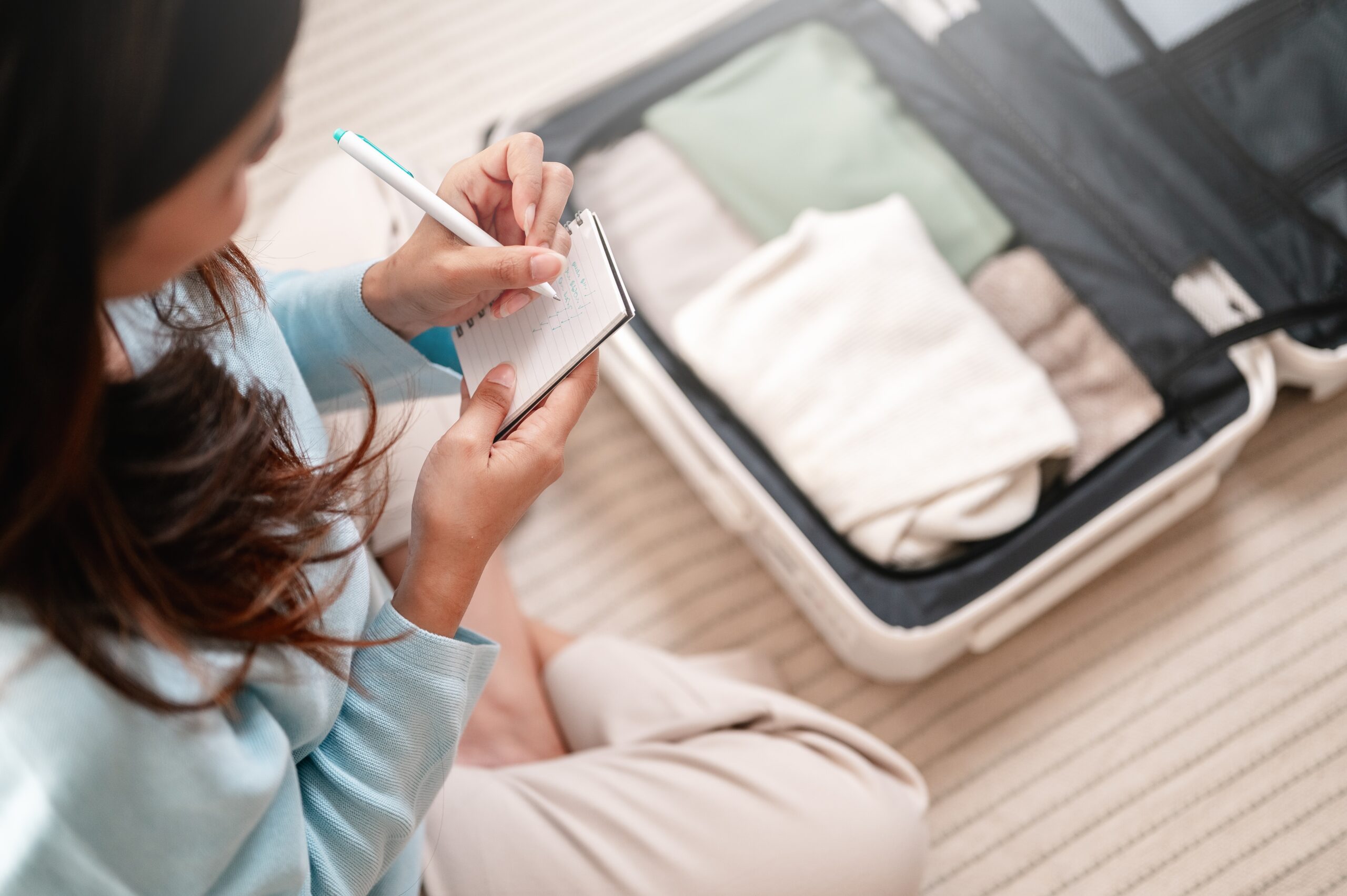 woman packing and writing packing list